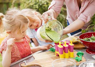 Two little Girls Preparing Popsicles Outside